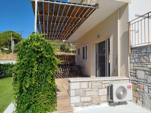 a house with a hedge in front of a house at Nereids Apartments-Pronoe in Petalidhion