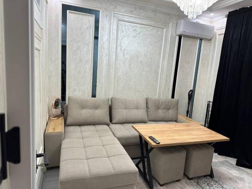 een woonkamer met een bank en een tafel bij Luxanda Plaza in Samarkand