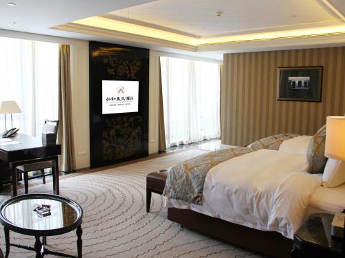 a hotel room with a large bed and a desk at RenHe Spring Hotel in Chengdu