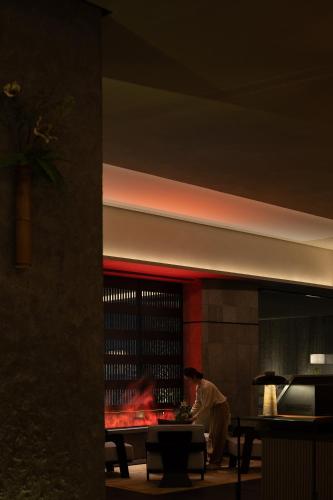a man standing in front of a building with a fireplace at Yomanju International Hotel -Guangzhou Tower Zhujiang NewTown Sports West Road Branch &地铁站- Canton Fair Exclusive Rate in Guangzhou