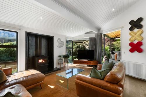 a living room with a couch and a fireplace at Arrowtown Luxury Escape Hot Tub Central Heating in Arrowtown