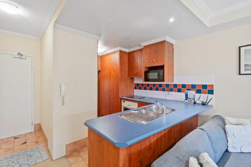 a kitchen with a blue counter top and a couch at Crystal Bay On The Broadwater in Gold Coast