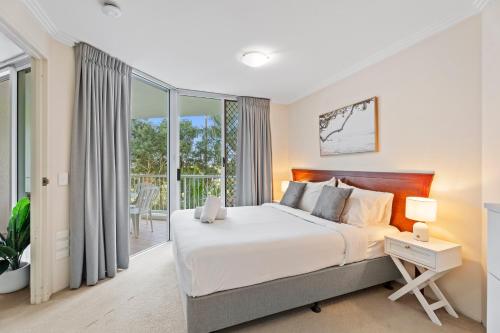a bedroom with a large bed and a balcony at Crystal Bay On The Broadwater in Gold Coast
