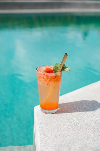 a drink sitting on a table next to a pool at Suksma Guesthouse in Canggu