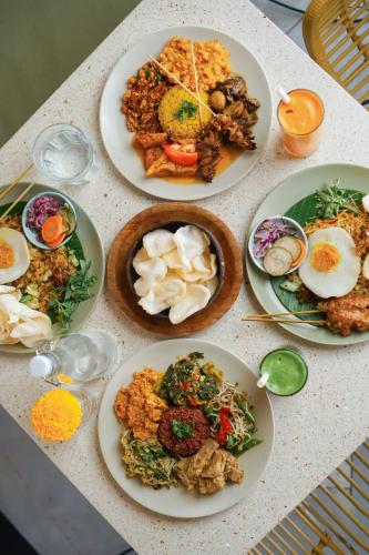 a table with plates of food on it at Suksma Guesthouse in Canggu
