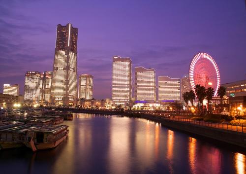 a city at night with a river and a ferris wheel at Sotetsu Fresa Inn Yokohama Totsuka - Renovated in March 31st 2025 in Yokohama