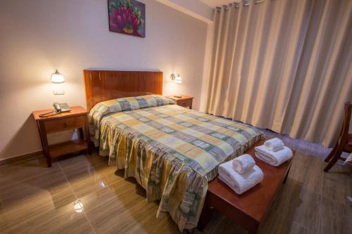 1 dormitorio con 1 cama y 2 toallas en una mesa en Amazonia Siu Hostal, en La Merced