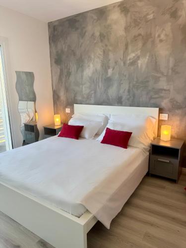 a bedroom with a large white bed with red pillows at Villa Carlotta in Salionze