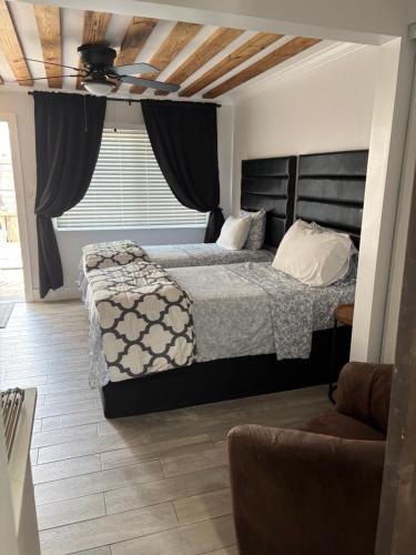 a bedroom with a bed and a chair and a window at Keese's Cottages by the Ocean in Fort Lauderdale