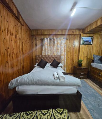a bedroom with a large bed with wooden walls at Zambalaas Inn in Darjeeling