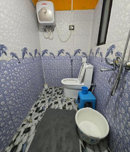 a blue bathroom with a toilet and a sink at Zambalaas Inn in Darjeeling