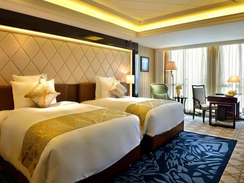 a hotel room with two beds and a desk at RenHe Spring Hotel in Chengdu