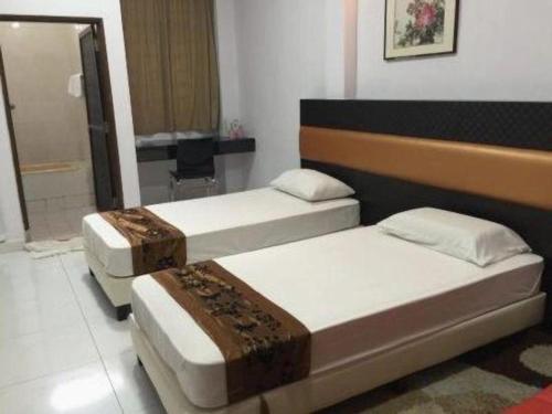 a bedroom with two beds and a desk at Lai Ming Hotel Cosmoland in Singapore