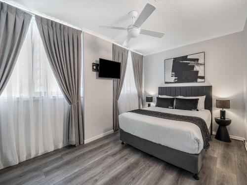 a bedroom with a bed and a ceiling fan at Sunny Coast Escapes - Maroochydore in Maroochydore