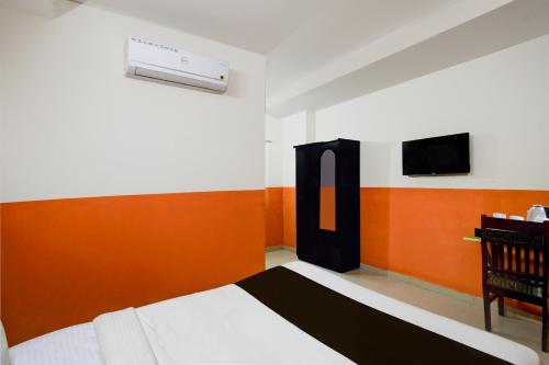 a bedroom with a bed and a tv in it at Super Collection O Atlas DLF Formerly Hillside in Kondapur