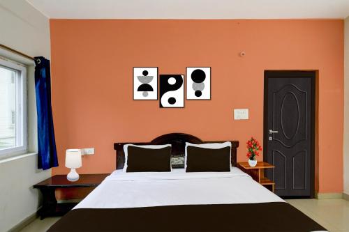 a bedroom with a bed with an orange wall at Super Collection O Atlas DLF Formerly Hillside in Kondapur