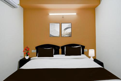 a bedroom with a bed and two pictures on the wall at Super Collection O Atlas DLF Formerly Hillside in Kondapur