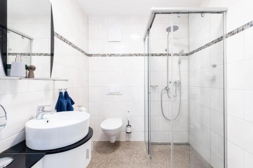 a white bathroom with a sink and a shower at FeWo Seeadler in Sassnitz
