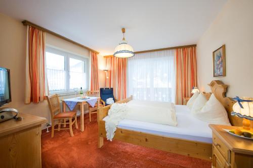 a bedroom with a large bed and a table at Pension St.Leonhard in Bad Gastein