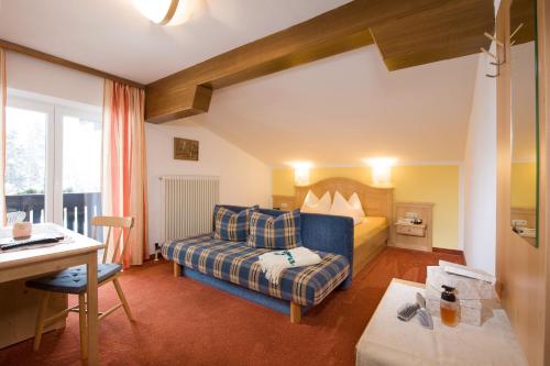 ein Hotelzimmer mit einem Bett und einem Schreibtisch in der Unterkunft Pension St.Leonhard in Bad Gastein