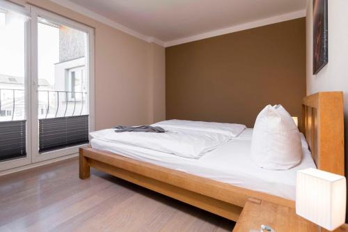 a bedroom with a bed with white sheets and a window at FeWo Fontane in Sassnitz