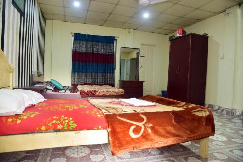 a bedroom with two beds and a mirror at Tea Heaven Eco Cottage in Sreemangal
