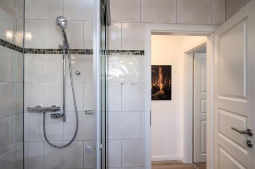 a bathroom with a shower with a glass door at FeWo Buchenfreund - Meerblick, Sauna, Kamin in Sassnitz