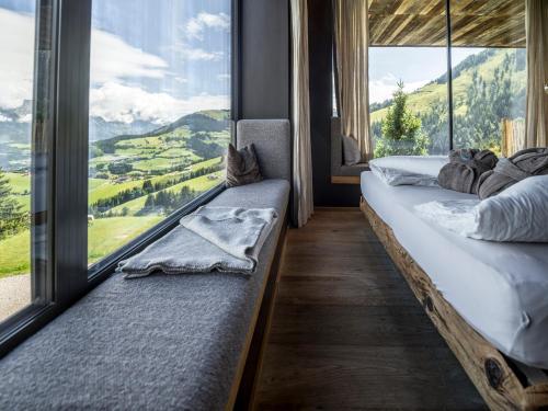 two beds in a room with a large window at KRAFTalm in Itter