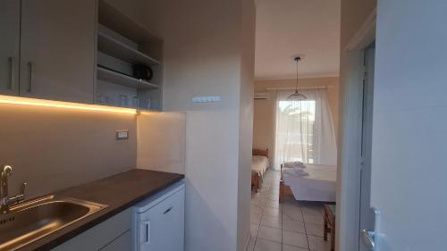 a kitchen with a sink and a bathroom with a tub at Sunflower Apartments & Studios in Laganas