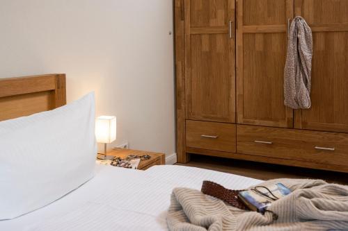 a bedroom with a bed and a wooden cabinet at Sassnitz - Kamin, Meerblick, Sauna, Fitness - FeWo Haubentaucher in Sassnitz