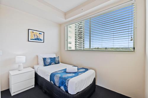a bedroom with a bed and a large window at Crystal Bay On The Broadwater in Gold Coast