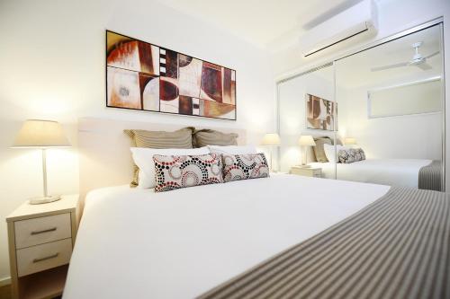 a white bedroom with a large white bed with pillows at Oaks Moranbah Suites in Moranbah