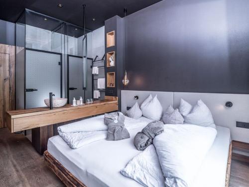 a bedroom with a large white bed and a bathroom at KRAFTalm in Itter