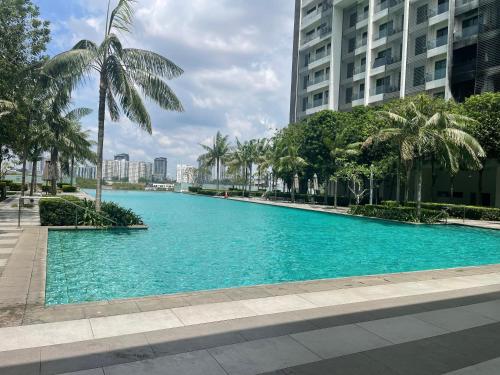a large blue swimming pool with palm trees and buildings at Cybersquare Lakeview with Netflix and Disney Hotstar in Cyberjaya