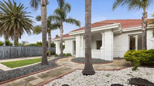 a house with palm trees in front of it at Marble Sands Beachside Studio at Rye in Rye