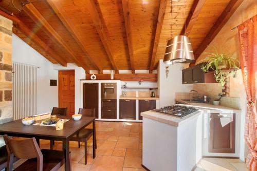 a kitchen with a wooden ceiling and a table at Anita Haus - Issime in Issime
