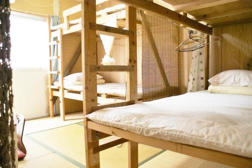 1 dormitorio con 2 literas y escalera en Minshuku Agaihama, en Yonabaru