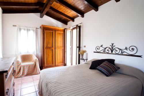 ein Schlafzimmer mit einem Bett, einem Stuhl und einem Fenster in der Unterkunft Terre Bianche Appartamenti in Dolceacqua