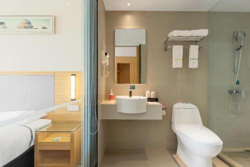 une salle de bain avec des toilettes blanches et un lavabo dans l'établissement City Comfort Inn Xianning South Station Wanda, à Wenquanzhen