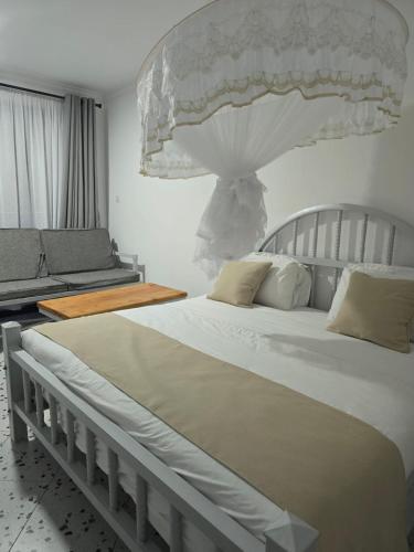a bedroom with a large white bed and a couch at 4Ps House Getaway in Kitui