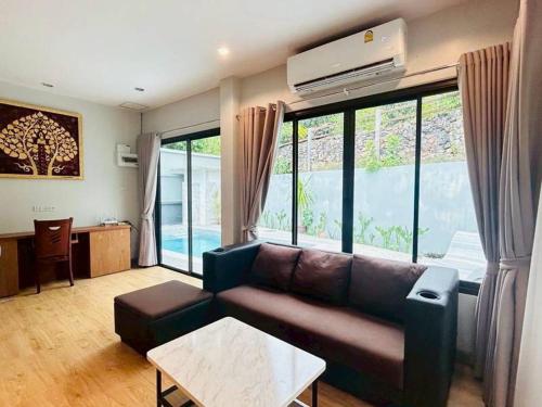 にあるMTM Pool Villaのソファとテーブルのあるリビングルーム