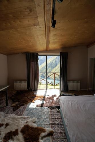 a room with two beds and a large window at Pana Unique Kolsay in Kurmenty