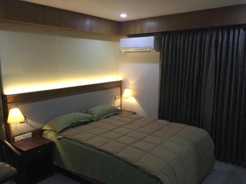 a bedroom with a bed with two green pillows at Premium ,modern 2 rooms apartment in Thiruvalla