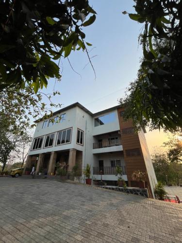 a large white building with a lot of windows at Kamal Farm Resort in Shenwa
