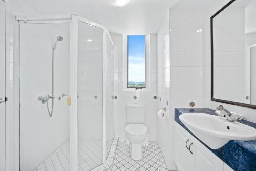 a white bathroom with a toilet and a sink at Crystal Bay On The Broadwater in Gold Coast