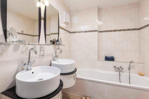 Un baño blanco con lavabo y bañera. en FeWo frische Brise, en Sassnitz
