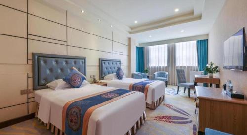 a hotel room with two beds and a desk at Chengdu Haotian Guotai Hotel in Chengdu