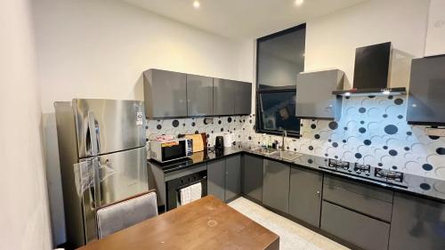a kitchen with stainless steel appliances and a wooden table at M8 Ocean King Three Bed Apartment in Cinnamon Gardens