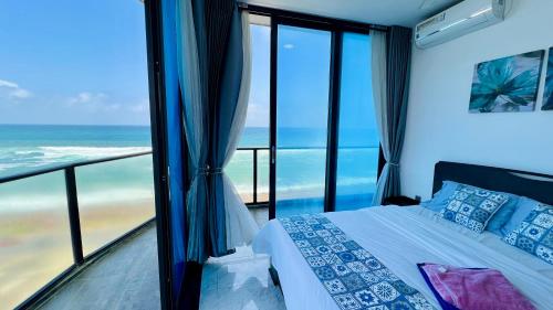 a bedroom with a bed and a view of the ocean at M8 Ocean King Three Bed Apartment in Cinnamon Gardens