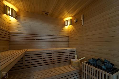 a wooden sauna with a bench and lights in it at Les Campanes - Gite 8 personnes avec piscine intérieure et sauna 